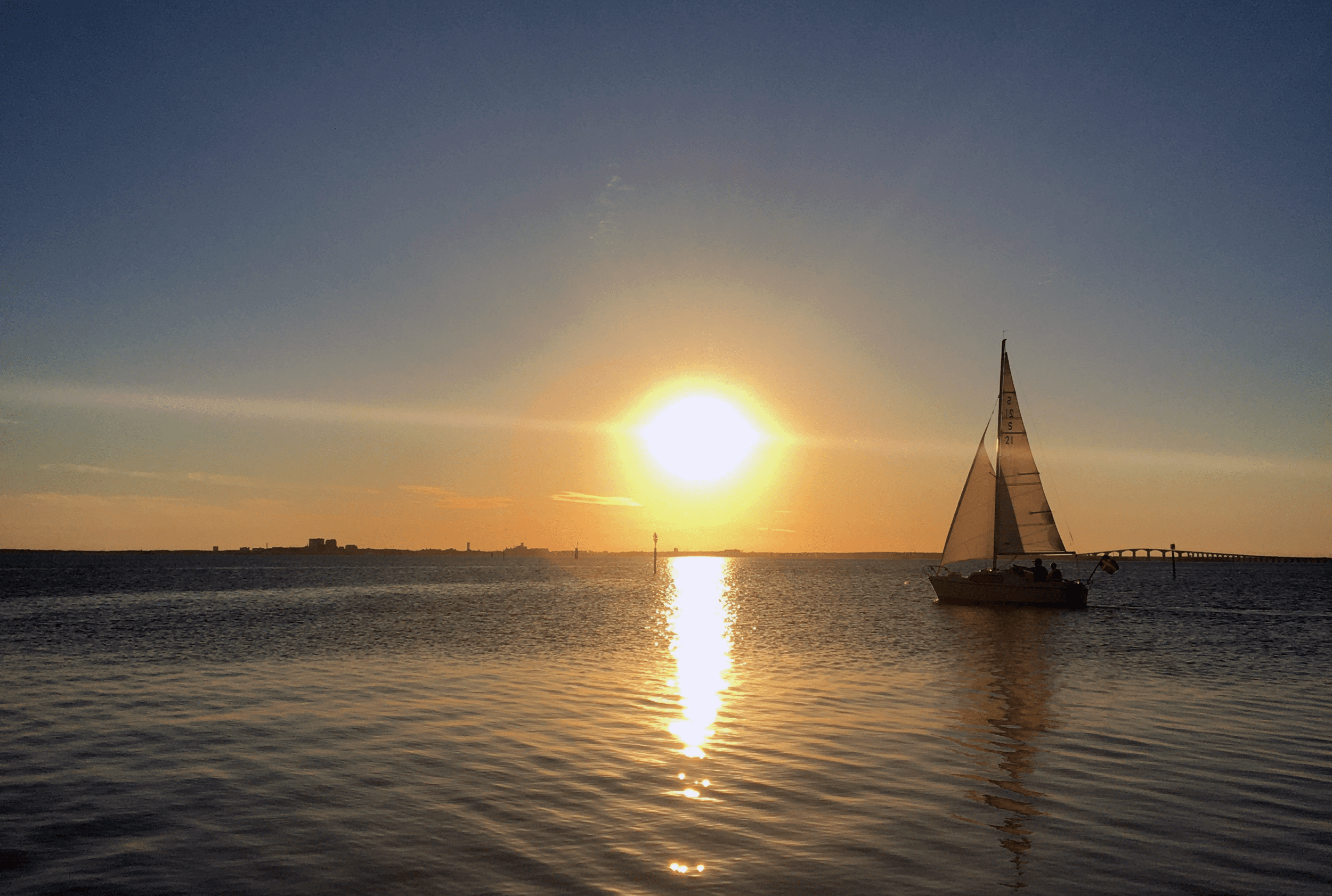 Segelbåt i solnedgång, Ölandsbron i bakgrunden.